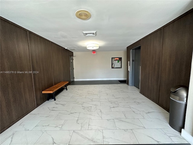 corridor with light tile patterned flooring and elevator