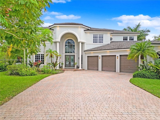 mediterranean / spanish house with french doors and a garage