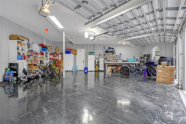 garage with a workshop area, white fridge, and a garage door opener