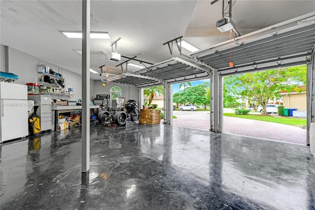 garage featuring white refrigerator and a garage door opener