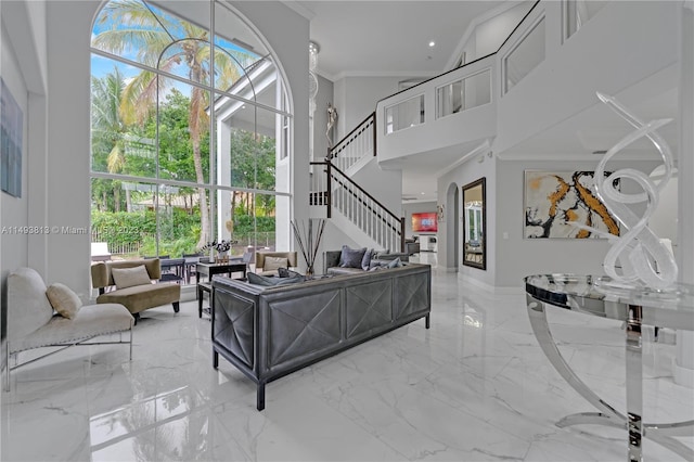 living room with a towering ceiling and crown molding