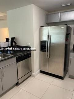 kitchen with gray cabinets, light tile patterned flooring, and stainless steel appliances