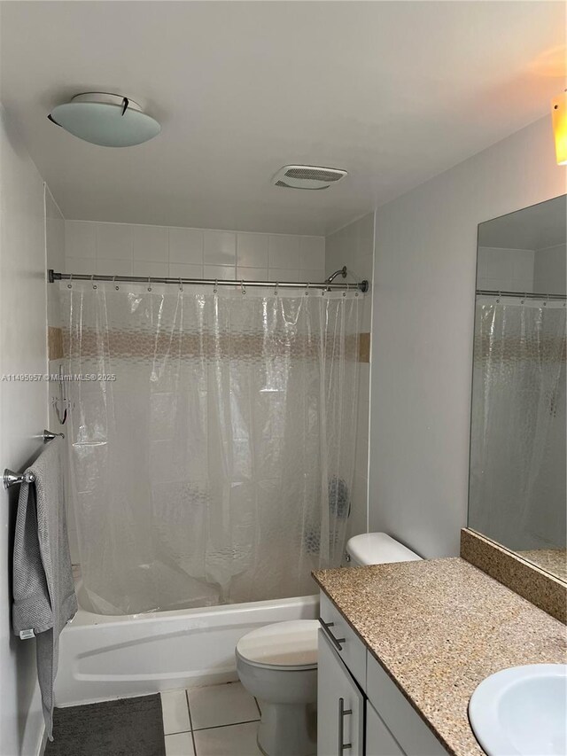 full bathroom featuring tile patterned floors, vanity, shower / bath combination with curtain, and toilet