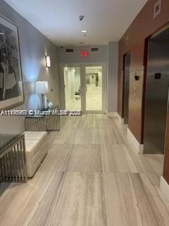 hallway featuring light wood-type flooring and elevator