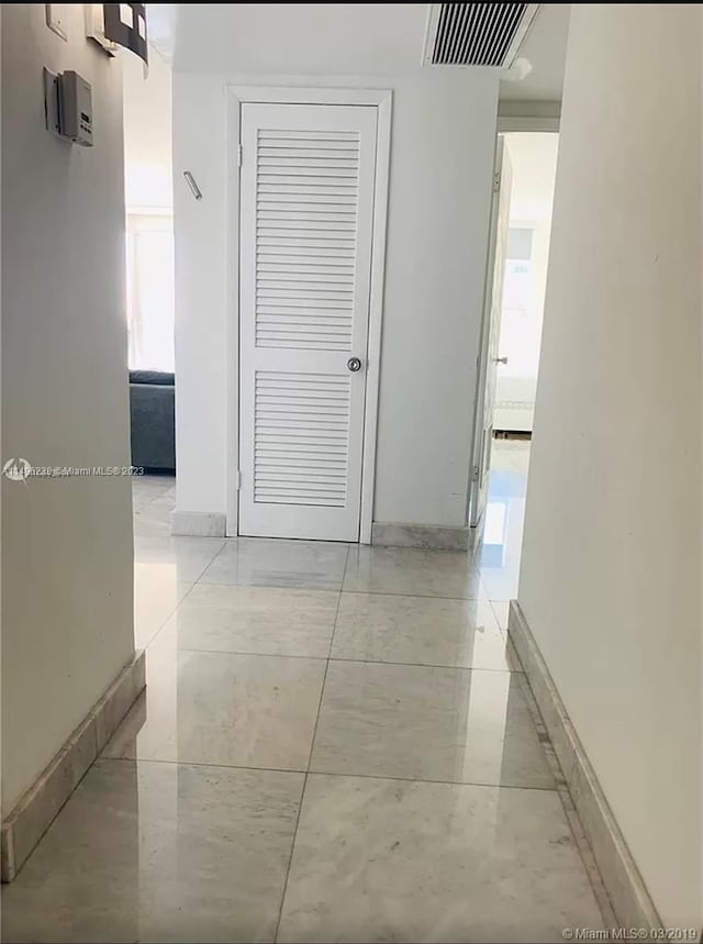 hallway featuring light tile flooring and a healthy amount of sunlight