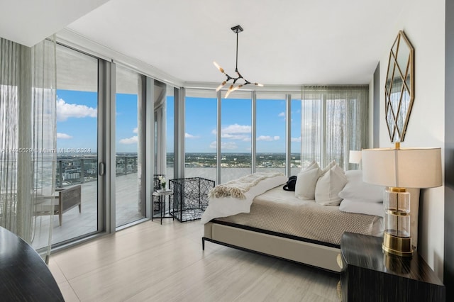 bedroom featuring light hardwood / wood-style floors, a notable chandelier, access to outside, and a wall of windows