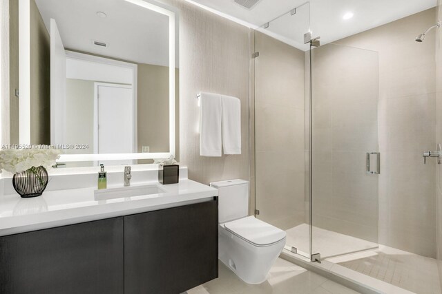 bathroom with walk in shower, vanity, toilet, and tile floors