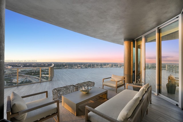 balcony at dusk with a water view and an outdoor living space