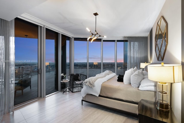 bedroom with expansive windows, a chandelier, and access to outside