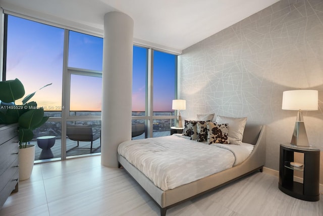 bedroom with a wall of windows and multiple windows