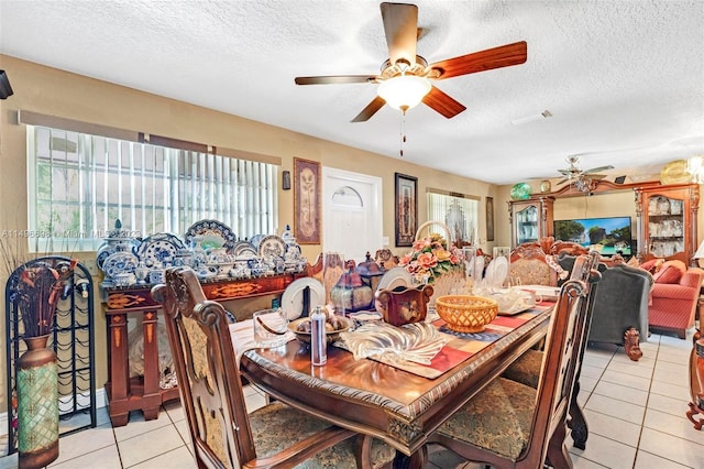 tiled dining room with a textured ceiling and ceiling fan