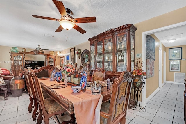 dining space with a textured ceiling, light tile patterned floors, and ceiling fan