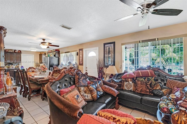 tiled living room featuring a textured ceiling and ceiling fan