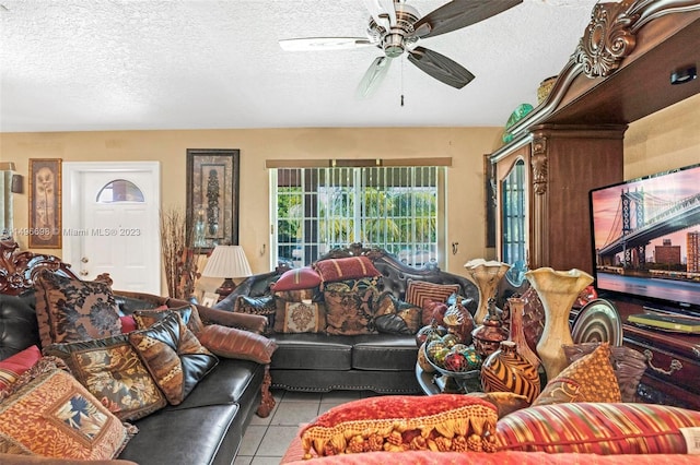 living room featuring a textured ceiling, light tile patterned floors, and ceiling fan