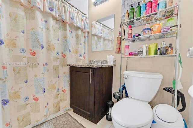 bathroom with vanity, tile patterned flooring, and toilet