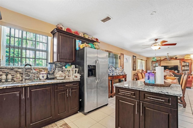 kitchen featuring light tile patterned floors, tasteful backsplash, stainless steel refrigerator with ice dispenser, and ceiling fan