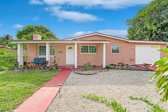 single story home with a porch, a garage, and a front yard