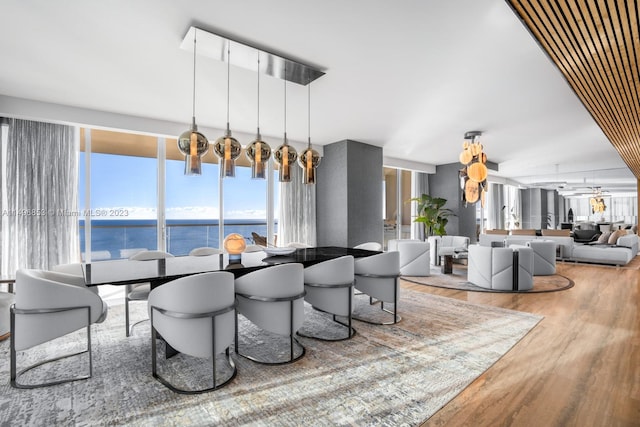 dining room with a water view, wood-type flooring, and expansive windows