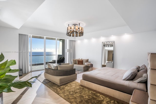 bedroom featuring an inviting chandelier, a water view, and access to outside