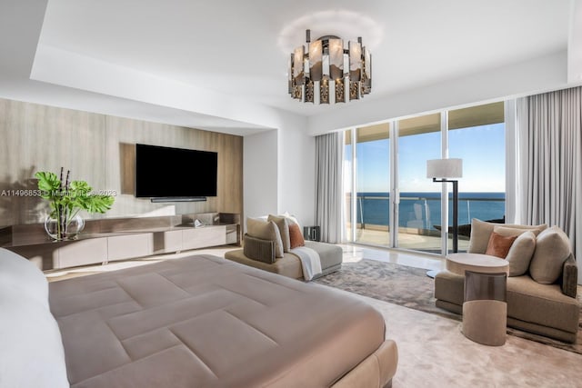 carpeted living room featuring a water view and a chandelier