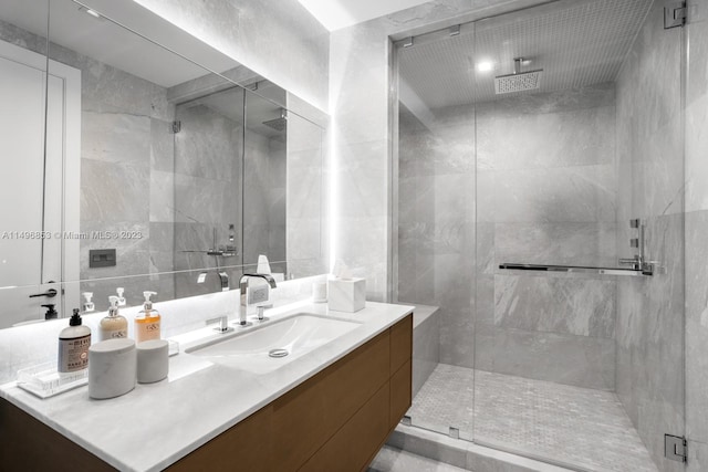 bathroom featuring vanity, walk in shower, and tile walls