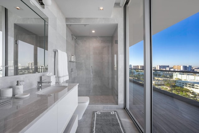 bathroom with vanity, toilet, walk in shower, and tile walls