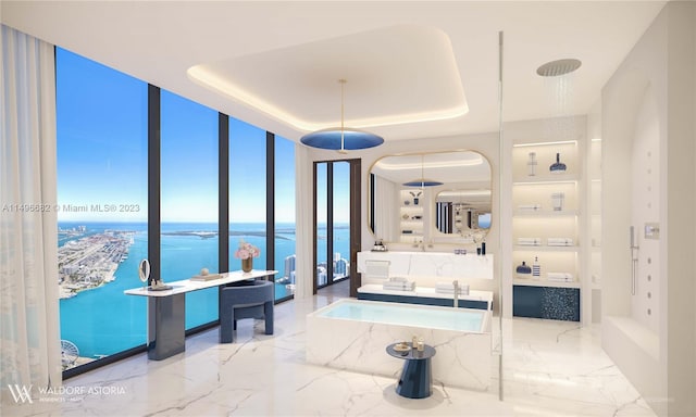 bathroom featuring a raised ceiling, a washtub, tile patterned floors, a wall of windows, and a water view