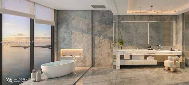 bathroom with tile walls, a bathing tub, and vanity