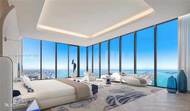 tiled bedroom featuring floor to ceiling windows, a water view, and a raised ceiling