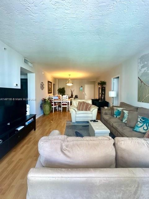 living room featuring a textured ceiling and hardwood / wood-style flooring