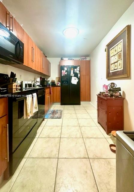 kitchen with light tile patterned flooring and black appliances