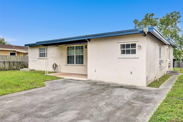 back of house with a lawn and a patio area