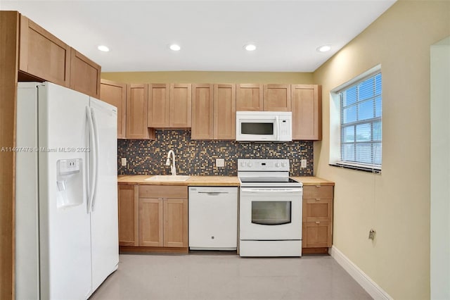 kitchen featuring backsplash, light tile floors, white appliances, and sink