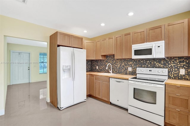 kitchen featuring white appliances, tasteful backsplash, sink, and light tile floors