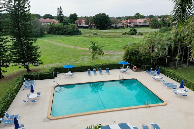 view of swimming pool featuring a yard and a patio