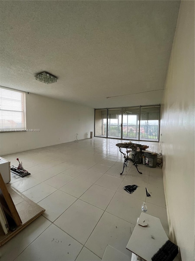 tiled empty room featuring a textured ceiling