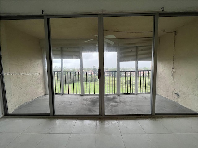 doorway to outside with ceiling fan and light tile patterned flooring