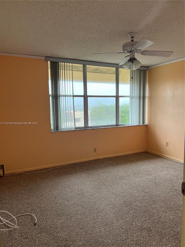 carpeted spare room with ceiling fan, a textured ceiling, and ornamental molding