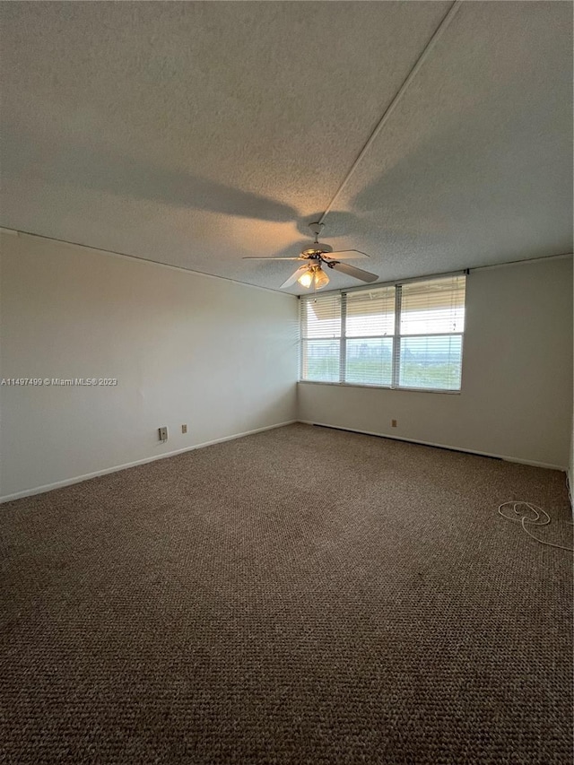 carpeted empty room featuring ceiling fan and a textured ceiling