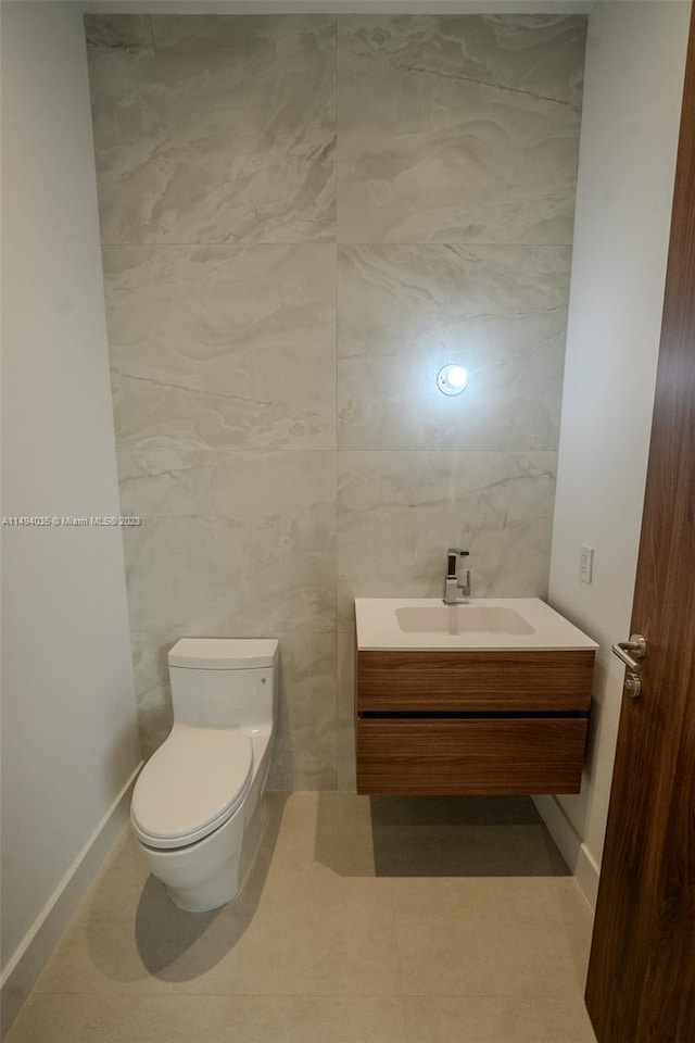 bathroom with toilet, vanity, and tile walls