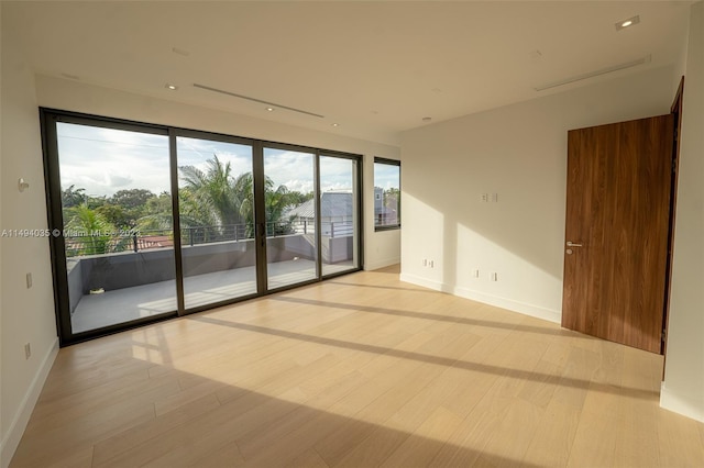 unfurnished room with light wood finished floors and baseboards