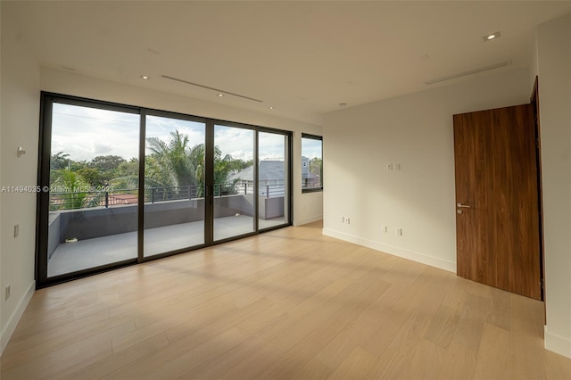 spare room with light wood finished floors and baseboards