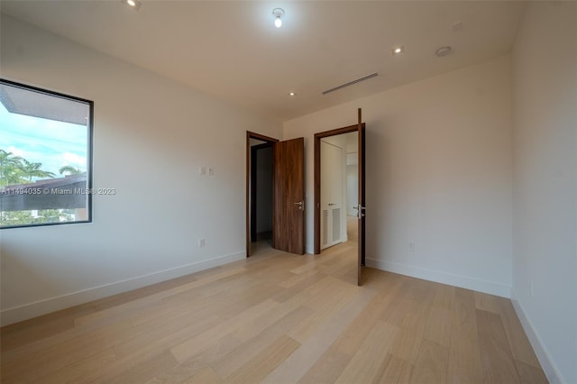 unfurnished room featuring light wood-style floors, recessed lighting, and baseboards