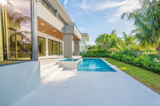 view of pool featuring french doors, a patio area, a fenced backyard, and a pool with connected hot tub