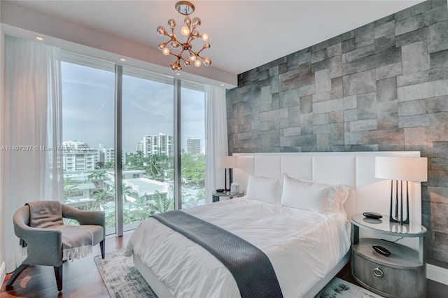 bedroom with hardwood / wood-style flooring, access to outside, multiple windows, and a notable chandelier