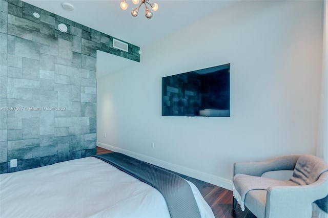 bedroom with a chandelier and dark hardwood / wood-style flooring