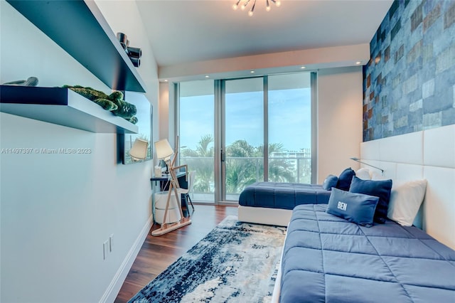 bedroom featuring expansive windows and hardwood / wood-style floors