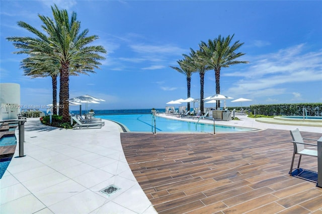 view of pool featuring a patio and a water view