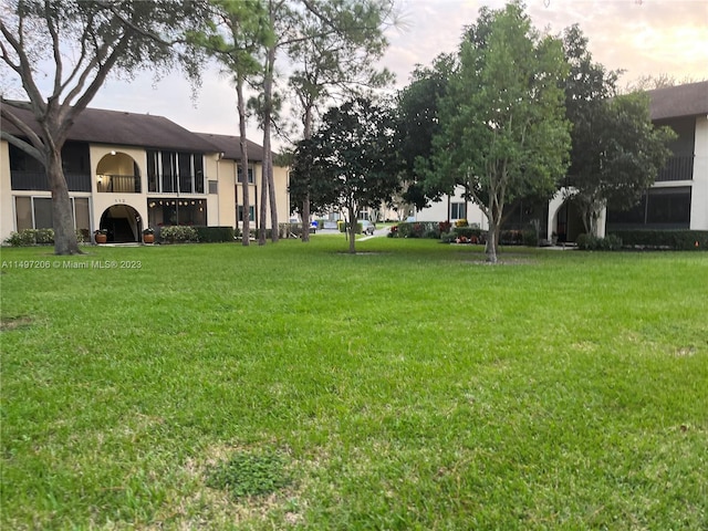 yard at dusk featuring a balcony