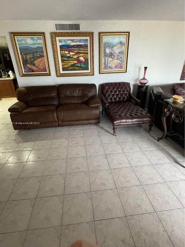 tiled living room featuring a textured ceiling